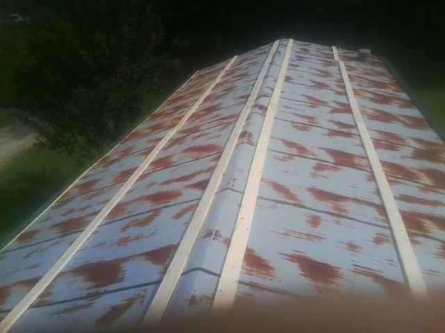 Rusted metal roof panels with new wood purlins before replacement — Storm Damage Roof Repair in Mineral Springs by Roofing Brothers